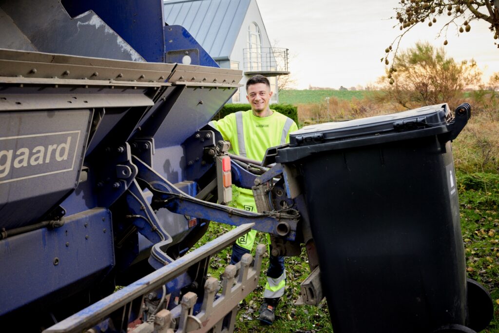 Renovationsmedarbejder klargør skraldespand til tømning ved Meldgaard-skraldebilen.